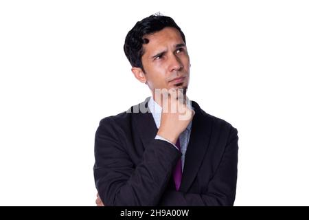 Elegant man puts his hand on his chin with thoughtful expression, Young adult latin man isolated on all white background. Stock Photo