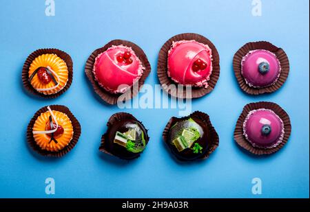 Assorted mousse cakes on blue background top view Stock Photo