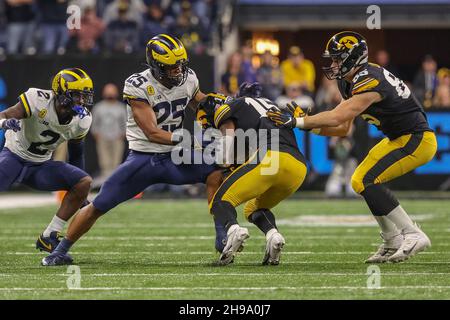 Indianapolis, Indiana, USA. 4th Dec, 2021. Iowa Hawkeyes running back Tyler Goodson (15) is stopped by Michigan Wolverines linebacker Junior Colson (25) on a run in the game between the Michigan Wolverines and the Iowa Hawkeyes at Lucas Oil Stadium, Indianapolis, Indiana. (Credit Image: © Scott Stuart/ZUMA Press Wire) Stock Photo