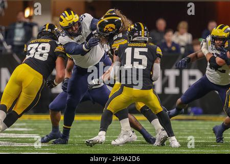 Indianapolis, Indiana, USA. 4th Dec, 2021. Iowa Hawkeyes running back Tyler Goodson (15) runs the ball behind a block from Iowa Hawkeyes offensive lineman Kyler Schott (64) on Michigan Wolverines defensive end Gabe Newburg (99) in the game between the Michigan Wolverines and the Iowa Hawkeyes at Lucas Oil Stadium, Indianapolis, Indiana. (Credit Image: © Scott Stuart/ZUMA Press Wire) Stock Photo