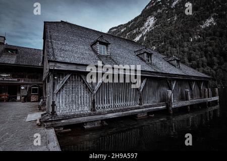 Mountain lake Konigsee in Germany, historic boathouse next to St. Bartholoma church Stock Photo