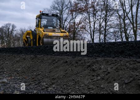 Close up view of a road roller working on a new road construction site. Stock Photo