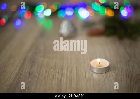 Christmas Composition of Candle on a Wooden Background With colorful Light Stock Photo
