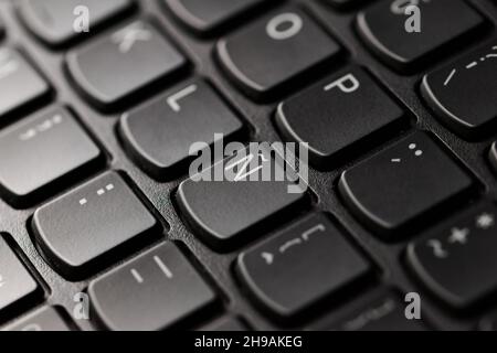 Black laptop computer keyboard, extreme close up focusing in the spanish character Ñ. Stock Photo