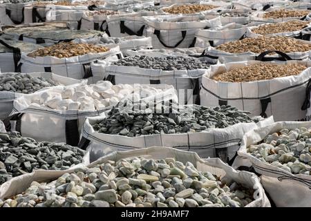 A lot of one cubic meter bags filled with variations of garden decorative crushed stones in the Hardware Store. Stock Photo