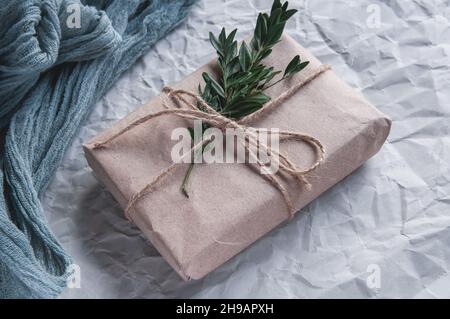 Gift box next to vintage Gauze gray and spruce leaves red berries, holiday composition on gray paper Stock Photo