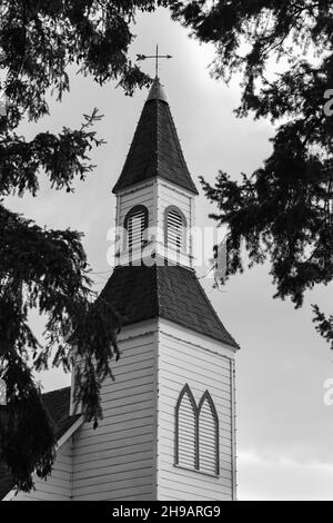 Photo of a little white wooden church in the countryside. Church in rural British Columbia, Canada. Street view, travel photo, selective focus, Stock Photo