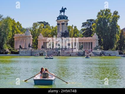 Rowing boat on Retiro Pond in Buen Retiro Park and monument to Alfonso XII, Madrid, Spain Stock Photo