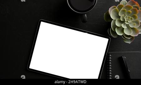 Modern digital tablet computer blank screen mockup on dark worktable. top view, flat lay Stock Photo