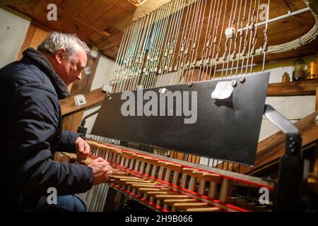 Magdeburg, Germany. 01st Dec, 2021. Music teacher Frank Müller plays the carillon in the bell tower of the town hall of the state capital Magdeburg. The instrument manually moves the bells from the town hall by means of metal pulls. The instrument was built by the Apolda bell foundry and inaugurated in 1974. Already at that time the music teacher played this instrument according to his own information as a music pupil. Until Christmas Eve, the carillon is to ring out with Christmas carols every Wednesday from 17:15 to 17:45. Credit: Klaus-Dietmar Gabbert/dpa-Zentralbild/ZB/dpa/Alamy Live News Stock Photo