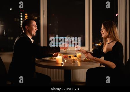 Evening date millennial couple, Caucasian family in love having a romantic moment, celebrate wedding anniversary together with dinner. valentine's day Stock Photo