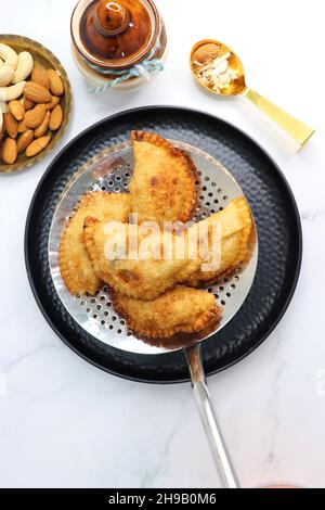 Indian Holi festival snack known as Gujia or Gujiya. Also called Karanji in Maharashtra, mostly eaten during Diwali. It is a deep fried sweet dish. Stock Photo