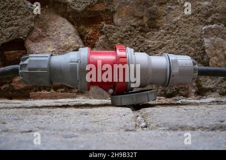 High voltage connector which comes from generator over old town ground. Selective focus Stock Photo