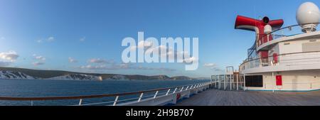 Weymouth Bay, England - July 5, 2020: Panoramic shot of open decks and red funnel on Carnival Valor. White cliffs, blue sky with white clouds in the b Stock Photo