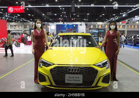 Parkked, Thailand. 04th Dec, 2021. Pretty girl standing next to an Audi car for the photographer to take a photo.The event 'The 38th Motor Expo - Motor Expo 2021' under the concept of 'Happy Motor Vehicles' (TIME to ENJOY!), a meeting place and exchanging opinions of those who love cars This event collects new cars of the year. with full promotions for the end of the year 2021, starting from 1-12 December 2021 at the IMPACT Challenger 1-3 Building, Muang Thong Thani. (Photo by Atiwat Silpamethanont/Pacific Press) Credit: Pacific Press Media Production Corp./Alamy Live News Stock Photo