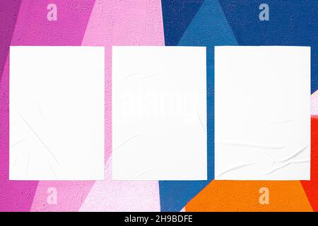 abstract colorful urban wall with three glued posters Stock Photo