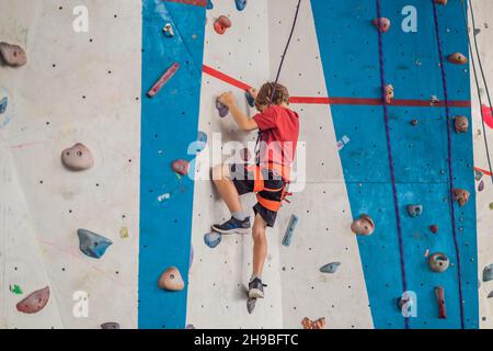 Boy at the climbing wall without a helmet, danger at the climbing wall Stock Photo