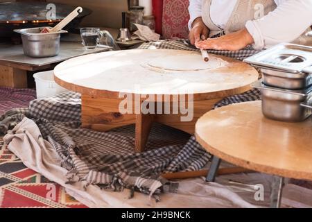Turkish Food. Gozleme Turkish stuffed flatbread cooking process in traditional style. Flatten dough by rolling pin. Stock Photo