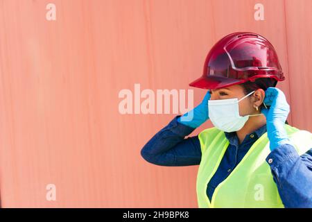 Industry worker with protective mask putting on safety helmet Stock Photo