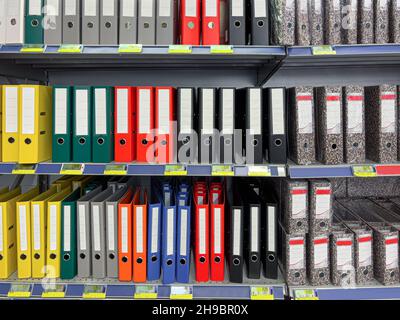 Multicolored Files and folders with blank labels displayed on store shelf. Stock Photo