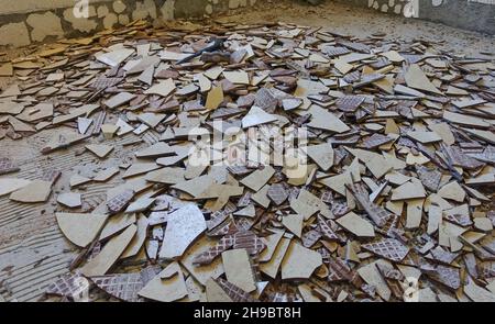 A kitchen floor covered with broken floor tiles. Stock Photo
