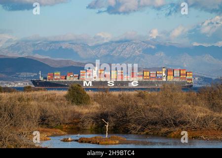 Msc, Container ship near Malaga, with Guadalhorce natural park in front, Andalucia, Spain. Stock Photo