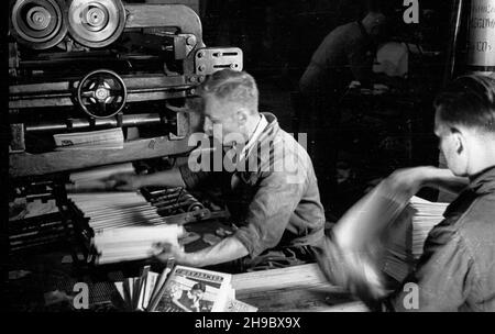 Warszawa, 1947-09-26. Drukarnia Spó³dzielni Wydawniczej Czytelnik przy ul. Marsza³kowskiej. Cykl produkcji dziennika gospodarczego pt. Rzeczpospolita. Nz. pracownicy odbieraj¹ z podajnika gotowe egzemplarze gazety.  bk/mgs  PAP      Warsaw, Sept. 26, 1947. Printing house of the Czytelnik publishing cooperative on Marszalkowska Street. Production of the economic daily Rzeczpospolita. Pictured: finshed copies of a paper.  bk/mgs  PAP Stock Photo