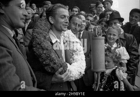 Warszawa, 1947-09-28. Stadion wojskowego Klubu Sportowego Legia. Pierwszy powojenny Wyœcig Kolarski Dooko³a Polski na trasie Kraków–Warszawa (VI Tour de Pologne). Nz. przed mikrofonem zwyciêzca w klasyfikacji ogólnej ca³ego wyœcigu - Stanis³aw Grzelak z klubu Tramwajarz £ódŸ. Na drugim planie m.in. dziewczynka - Krysia Tadeusiak (bia³a kokarda na g³owie), która chwilê wczeœniej wrêcza³a wieniec zawodnikowi.  bk/ppr  PAP      Warsaw, Sept. 28, 1947. Stadium of the Legia military sports club. The first cycling race around Poland after the war (VI Tour de Pologne) from Cracow to Warsaw. Pictured: Stock Photo