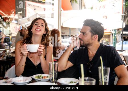 Young couple eating breakfast at an outdoor cafe in Tel Aviv, Israel Stock Photo