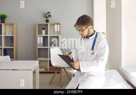 Male doctor prescribe medicines in medical card Stock Photo