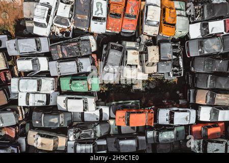 Aerial view of a Soviet automobile dump from a drone. Shooting from above at heaps of rusty cars. Abandoned Russian cars awaiting disposal and
