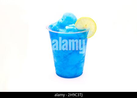 Electric blue lagoon slush lemonade with a slice of lemon in a disposable cup. Stock Photo