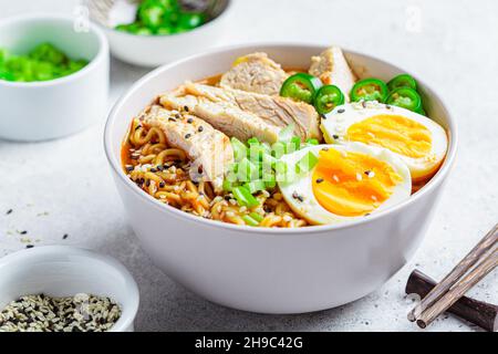 Asian noodle soup ramen with chicken and egg in a gray bowl. Japanese food concept. Stock Photo