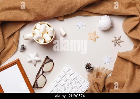 Christmas winter desktop. Marshmallow glasses keyboard frame scarf on a white background. Flat lay top view Stock Photo