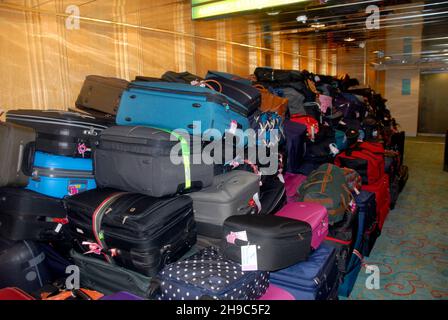 Luggage collected by porters from passengers on a cruise ship and placed in a temporary holding area before disembarking Stock Photo