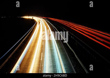 Moving cars at night on highway, long exposure. Motion blur effect of light trails. Fast speet traffic Stock Photo