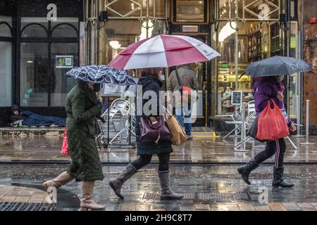 Shops, shoppers with umbrellas on a wet & windy in Preston, Lancashire.   Shopping in the city centre on a wet and windy day. A weather warning for 50mph winds is set to come into force as Storm Barra approaches.  Credit: MediaWorldImages/Ģ����ýLiveNews Stock Photo