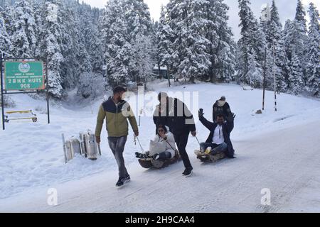 Indian tourists enjoy sledge ride at snow covered ski resort Gulmarg after the season's first heavy snowfall. Stock Photo