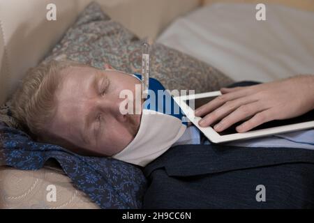 Covid-19. The man has an illness and works at home in office clothes. High quality photo Stock Photo