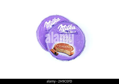 KHARKOV, UKRAINE - JULY 2, 2021: Milka chocolate product with classical lilac color wrapping design on white wooden table Stock Photo