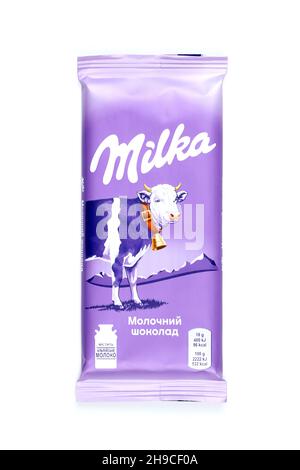 KHARKOV, UKRAINE - JULY 2, 2021: Milka chocolate product with classical lilac color wrapping design on white wooden table Stock Photo