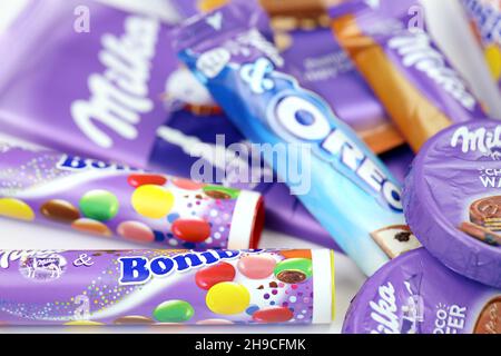 KHARKOV, UKRAINE - JULY 2, 2021: Milka chocolate products with classical lilac color wrapping design on white wooden table Stock Photo