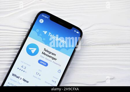 KHARKOV, UKRAINE - MARCH 5, 2021: Telegram Messenger icon and application from App store on iPhone 12 pro display screen on white wooden table Stock Photo