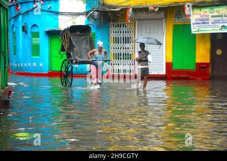 Kolkata, West Bengal, India. 6th Dec, 2021. Due to the Jawad cyclone, heavy to very heavy rainfall occurred. Many places were sucked in by water logging.The rickshaws keep passengers above the logged water and swim through the flooded streets. Kolkata is the only Indian city to keep up with the hand-pulled rickshaw, while this mode of transport pulled by one human being for the other has been rolled back from the rest of Asia. (Credit Image: © Rahul Sadhukhan/Pacific Press via ZUMA Press Wire) Stock Photo