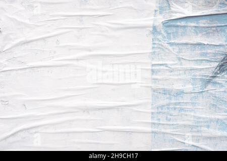 Shabby and messy crumpled and torn poster paper texture as graphic design element background, white paper scraps glued to a wall Stock Photo