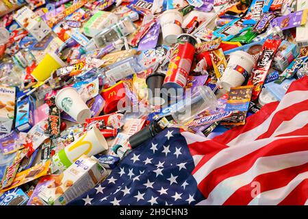 KHARKOV, UKRAINE - AUGUST 10, 2021: US flag on big pile of various wrappings and empty disposable packages and cups from famous branded food and drink Stock Photo