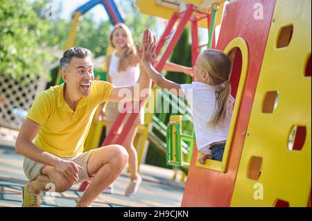 Famiy playing at the playground and feeling enjoyed Stock Photo