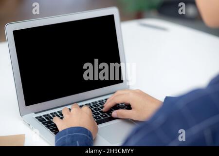 Young business man using laptop computer blank screen on desk at home, businessman work on notebook to internet online copy space for your text messag Stock Photo