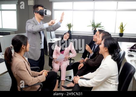Young businessman is developer design testing of connection metaverse on vr realistic in the office, development global of engineer for creative appli Stock Photo