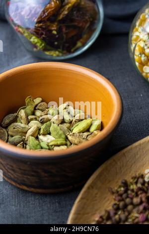 cardamon clay pot, sichuan paper in wood spoon, chilli paper and ...